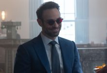 Charlie Cox sebagai Matt Murdock tersenyum di bank tentang Daredevil: Born Again