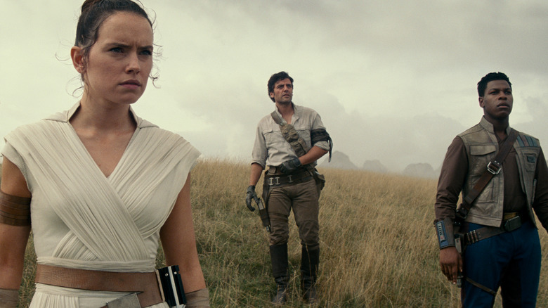 Rey (Daisy Ridley), Poe Dameron (Oscar Isaac), dan Finn (John Boyega) berdiri bersama, menyaksikan kerusakan bintang kematian kedua di dalam