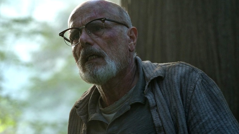 Joey Pants sebagai Eugene, tampak bingung di hutan di The Last of Us