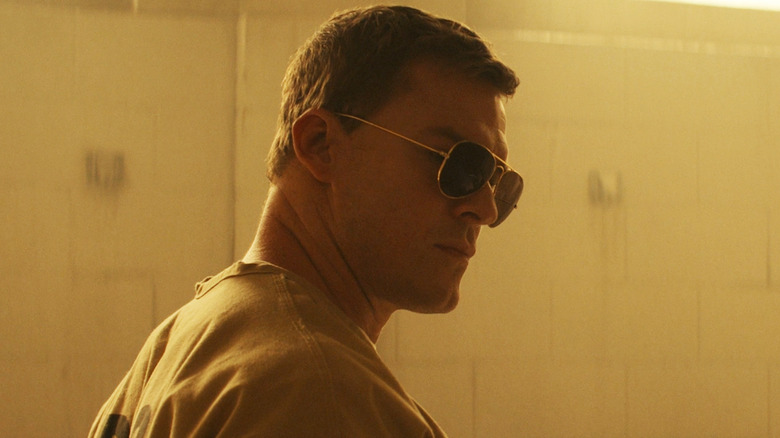 Stand Jack Reacher Alan Ritchson di kamar mandi penjara mengenakan nuansa di Reacher