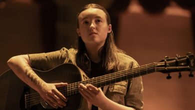 Bella Ramsey sebagai Ellie duduk dengan gitar di atas panggung di The Last of Us