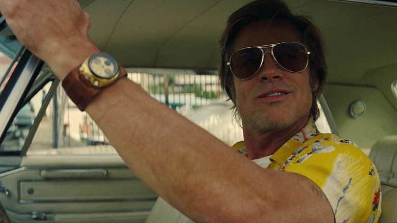Brad Pitt sebagai bilik tebing ginning sambil melihat ke luar jendela mobilnya dalam waktu sekali di Hollywood
