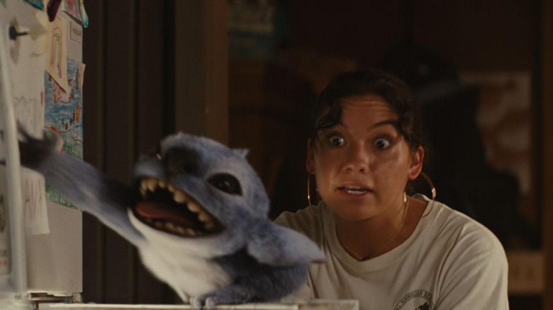 Jahitan meraih ke lemari es sementara Nani terlihat kesal di Lilo & Stitch