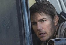Tom Cruise sebagai Mayor William Cage bersandar pada mobil