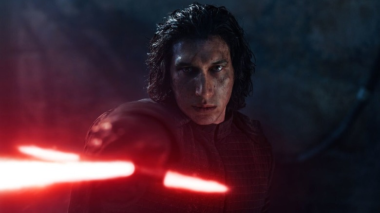 Adam Driver As Kylo Ren memegang lightsabernya di depannya di Star Wars: The Force Awakens