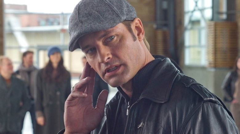 Josh Holloway in Mission: Impossible - Ghost Protocol mengenakan topi dan menyentuh wajahnya