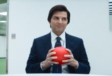 Mark S. memegang bola merah dan menyeringai pada pesangon