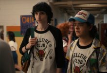 Mike dan Dustin mengenakan kemeja Hellfire Club mereka di sekolah di Stranger Things