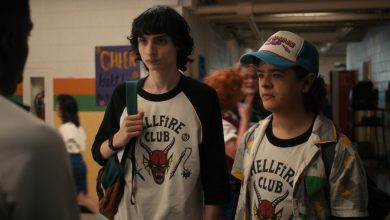 Mike dan Dustin mengenakan kemeja Hellfire Club mereka di sekolah di Stranger Things
