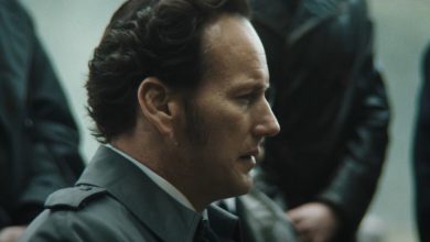 Patrick Wilson sebagai Ed Warren duduk di luar selama pemakaman di The Conjuring: Ritus Terakhir