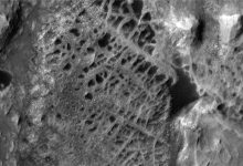Gambar satelit hitam dan putih dari fitur permukaan seperti spiderweb di Mars