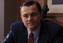 Leonardo DiCaprio sebagai Jordan Belfort tersenyum masam di Wolf of Wall Street