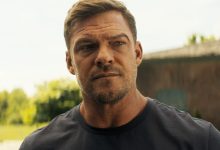 Alan Ritchson sebagai Jack Reacher berdiri di luar di Reacher