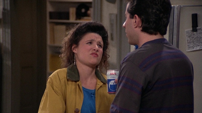 Elaine, mengenakan tampilan asam, menatap Jerry di Seinfeld.