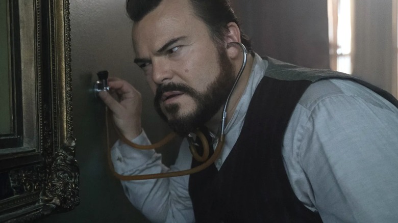 Jack Black seperti Jonathan mencoba mendengar jam di rumah dengan jam di dindingnya