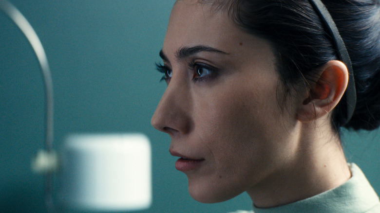 Gemma menatap lurus ke depan saat sedang dipelajari di laboratorium lumon di Severance Season 2