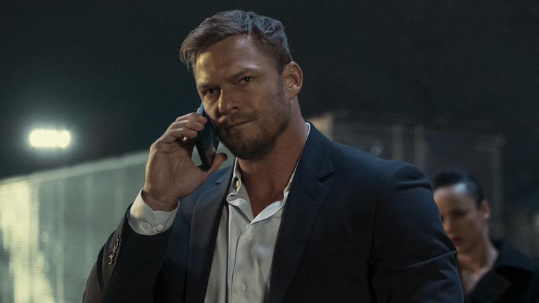 Reacher dalam setelan jas mendengarkan di telepon