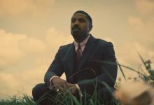 Michael B. Jordan sebagai asap berlutut di ladang di Sinners