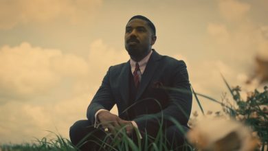 Michael B. Jordan sebagai asap berlutut di ladang di Sinners