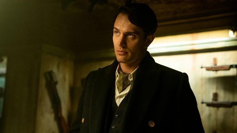 Colin Woodell sebagai Winston berdiri di sebuah ruangan yang penuh dengan senjata di benua: dari dunia John Wick