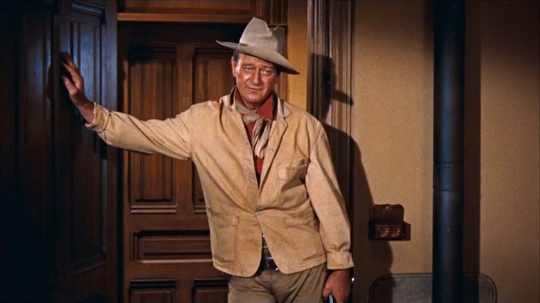 John Wayne berdiri di pintu seperti John T. Chance di Rio Bravo