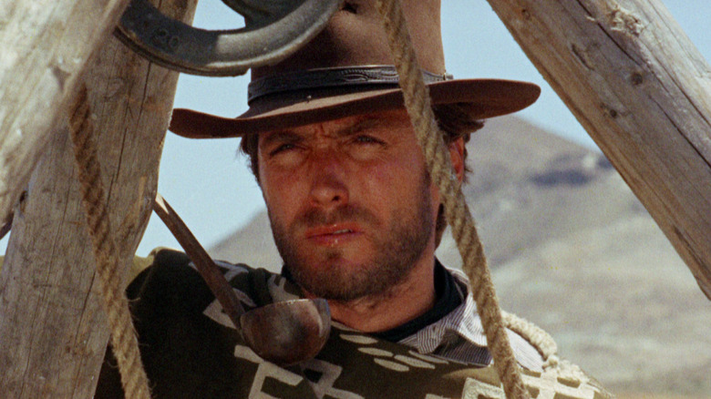 Clint Eastwood minum air dari sendok sebagai pria tanpa nama dalam fistful dolar