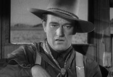 John Wayne's Henry menatap langsung, tampak berhantu, di Stagecoach