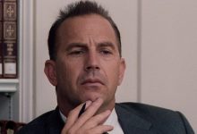 Kevin Costner membelai dagunya sebagai Kenneth O'Donnell dalam tiga belas hari