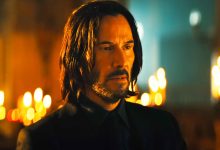 John Wick berdiri di ruang yang terang lilin di John Wick
