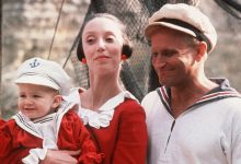 Robin Williams sebagai Popeye tersenyum sebagai Shelley Duvall sebagai Olive oyl cradles swee'pea baby in popeye