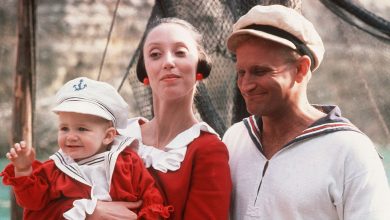 Robin Williams sebagai Popeye tersenyum sebagai Shelley Duvall sebagai Olive oyl cradles swee'pea baby in popeye