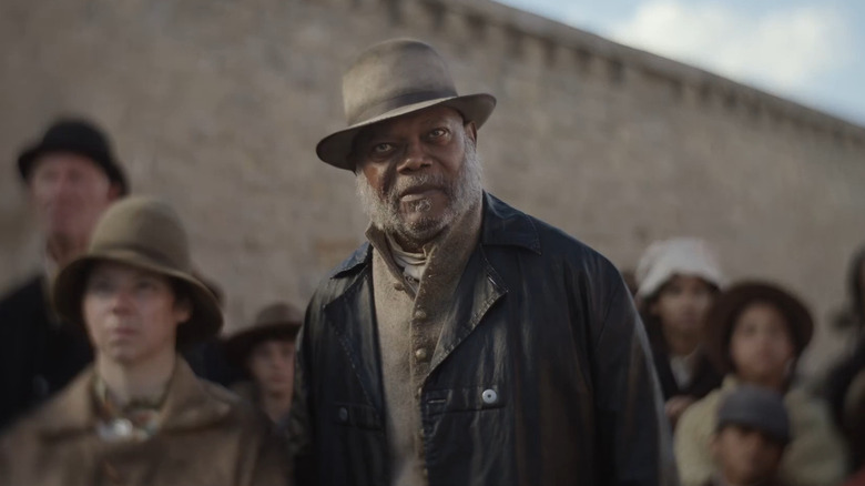 Samuel L. Jackson sebagai St. Christopher berdiri di depan kerumunan di Trinity yang tidak suci