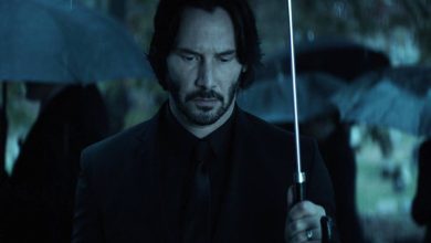 Keanu Reeves 'John Wick berdiri memegang payung di pemakaman di John Wick