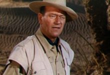 Joe Januari John Wayne berdiri di padang pasir di Legend of the Lost
