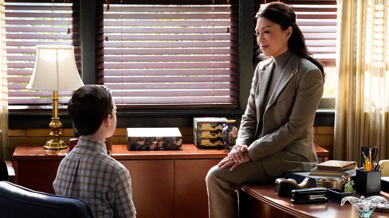 Carol Lee duduk di meja berbicara dengan Sheldon Cooper di Sheldon muda