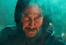 Keanu Reeves 'John Wick terlihat intens saat dia mengintip melalui asap di John Wick Bab 4