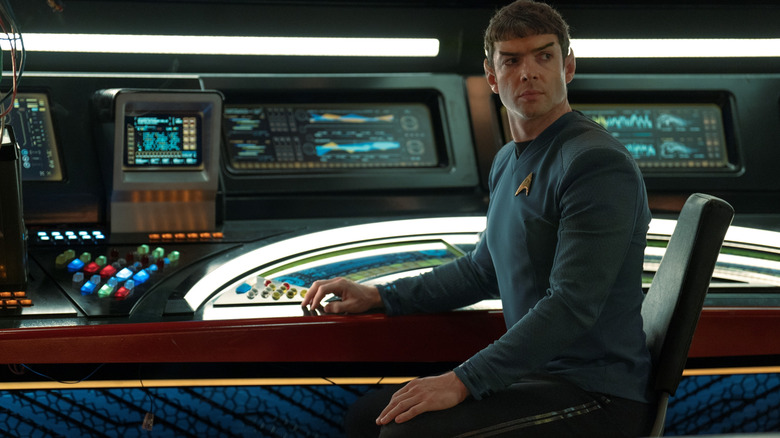 Ethan Peck saat Spock duduk di konsolnya di jembatan kapal luar angkasa di Star Trek: Strange New Worlds