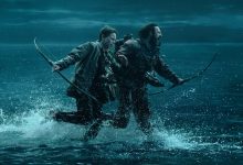Aaron Taylor-Johnson sebagai Jamie dan Alfie Williams sebagai putranya Spike berlari melintasi perairan yang dangkal jauh dari bahaya dalam 28 tahun kemudian
