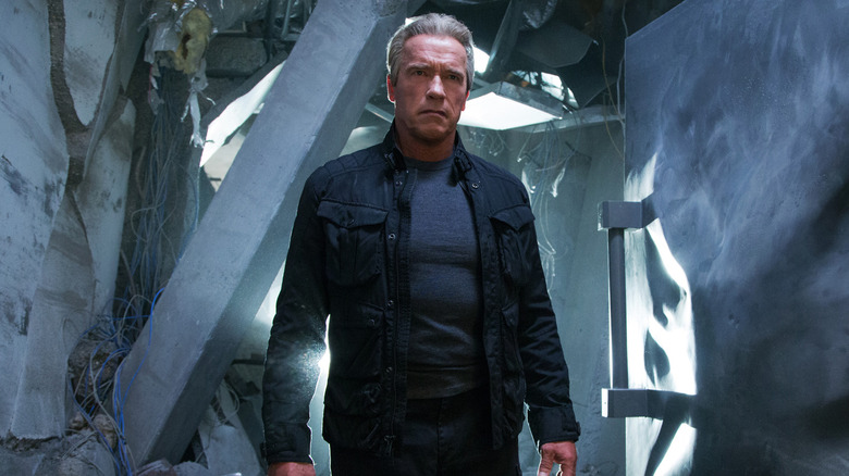 Arnold Schwarzenegger sebagai T-800 yang berdiri di lorong yang hancur di Terminator Genisys