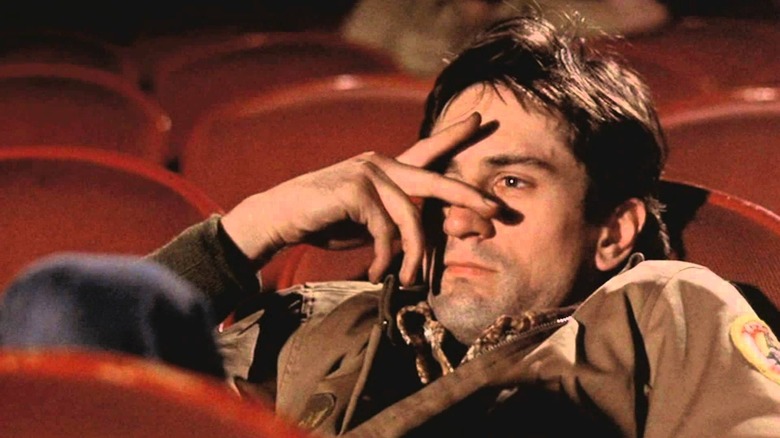 Robert De Niro sebagai Travis Bickle duduk di teater di sopir taksi
